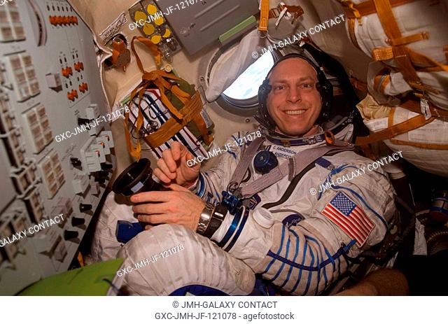 Attired in a Russian Sokol launch and entry suit, astronaut Clay Anderson, Expedition 15 flight engineer, is seated in the Soyuz TMA-10 spacecraft docked to the...