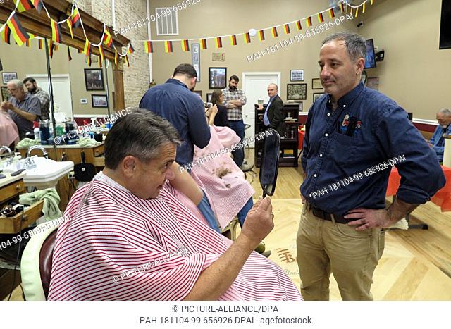 dpatop - 03 November 2018, US, Martinsburg: Sigmar Gabriel (SPD), former Federal Foreign Minister, looks at himself in a mirror after Jason Romage (r)