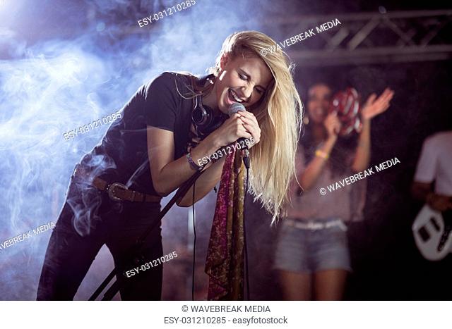 Cheerful female singer performing during music festival