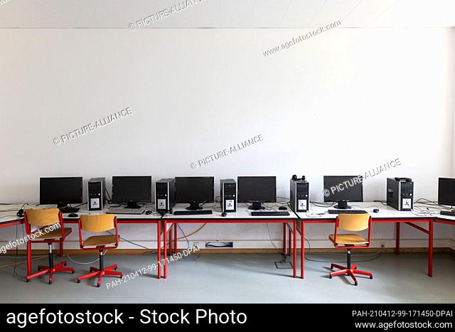 12 April 2021, Baden-Wuerttemberg, Heitersheim: Chairs stand in front of tables with computers in an empty classroom of a secondary school