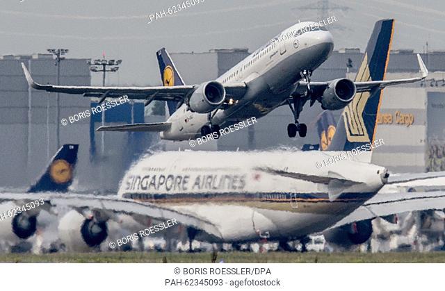 A Lufthansa passenger jet takes off in front of a taxiing Singapore Airlines Airbus A 380, in Frankfurt am Main, Germany, 5 October 2015