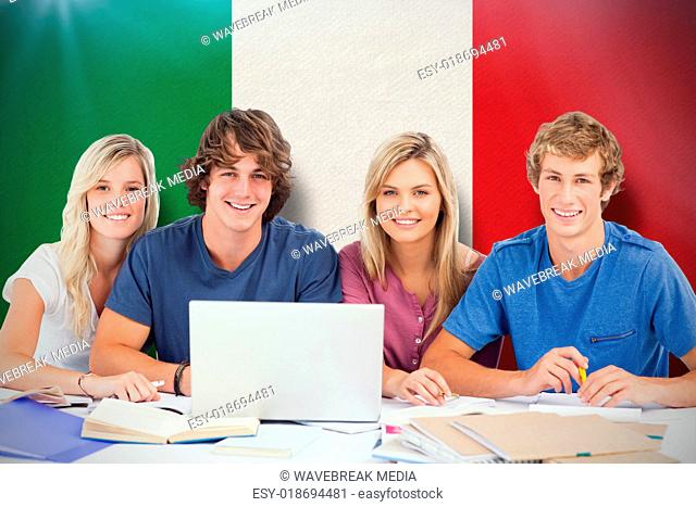 Composite image of a group of students with a laptop look into the camera