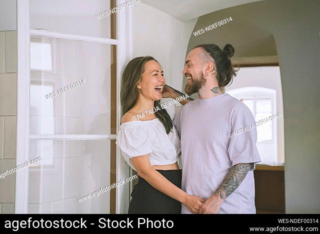 Happy hipster man with girlfriend at doorway