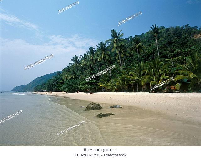 White Sand Beach, Haad Sai Khao. View along sandy shore with lush green trees growing inland