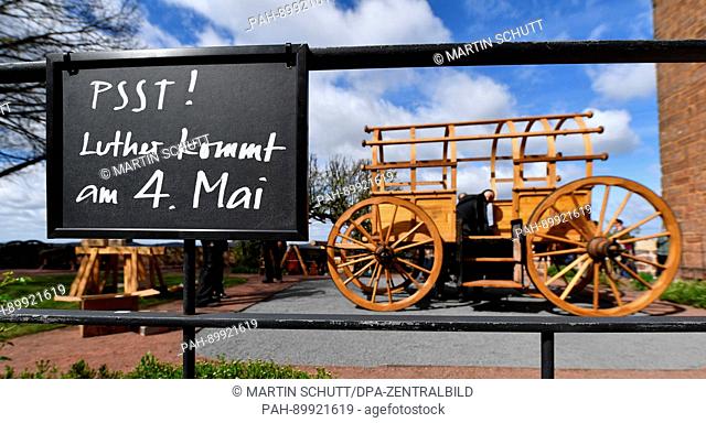 A sign reads 'Psst! Luther kommt am 4. Mai' (lit. Psst! Luther is coming on 4 May) as a faithful replica of 'Luthers Reisewagen' (lit