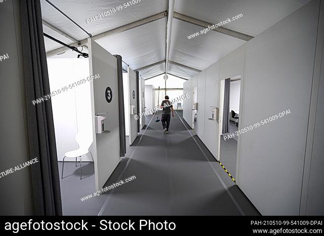 10 May 2021, Berlin: A man walks with a mop through the new vaccination tent in front of the Axel Springer building. Axel Springer Verlag will use the...