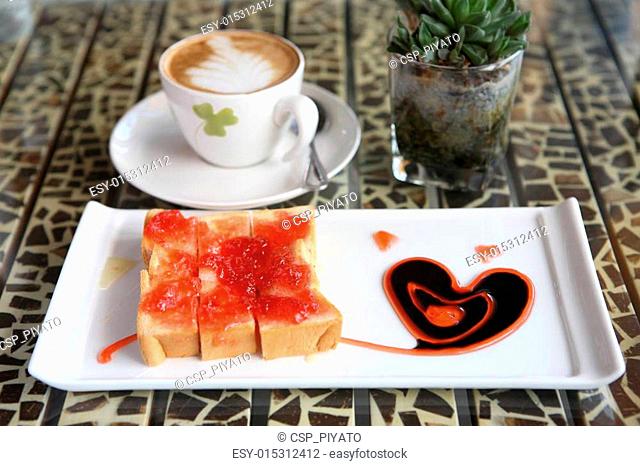 slice of bread with strawberry jam and coffee