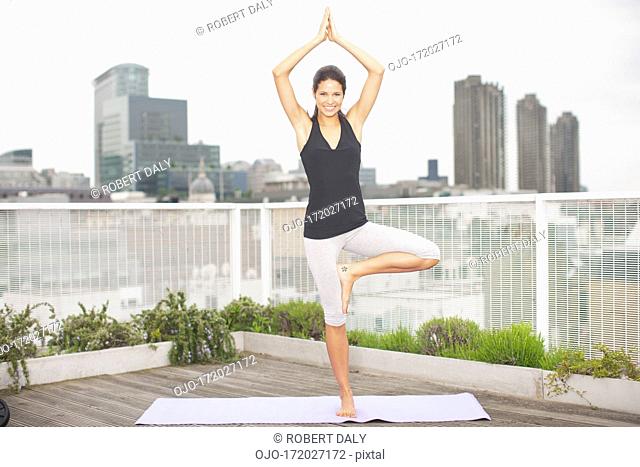 Woman practicing yoga on rooftop deck