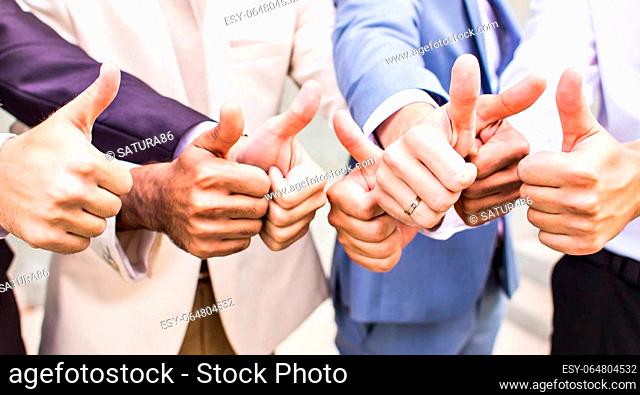 cheerful business group of people giving thumbs up