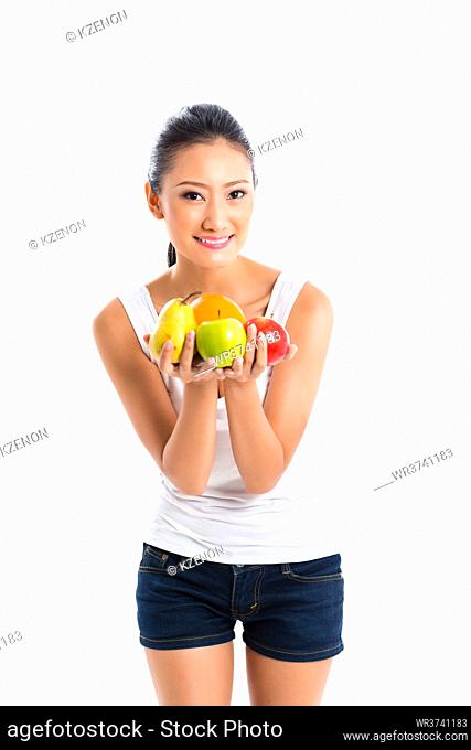 Young Asian woman offering fruits for healthy living wearing sportswear