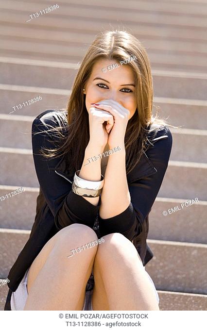 Beautiful girl with bare legs is sitting on stairs, Stock Photo