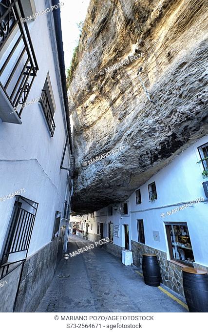 White homes constructed in caves sit under huge rocks in Setenil de las Bodegas village, Cadiz province, Andalusia, Spain