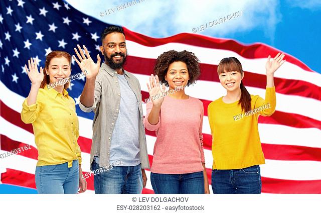 diversity, immigration and people concept - international group of happy smiling men and women waving hands over american flag background