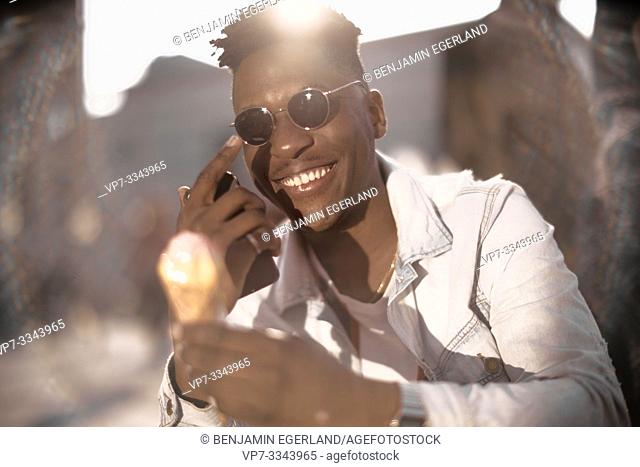happy young African man holding ice cream, in Munich, Germany