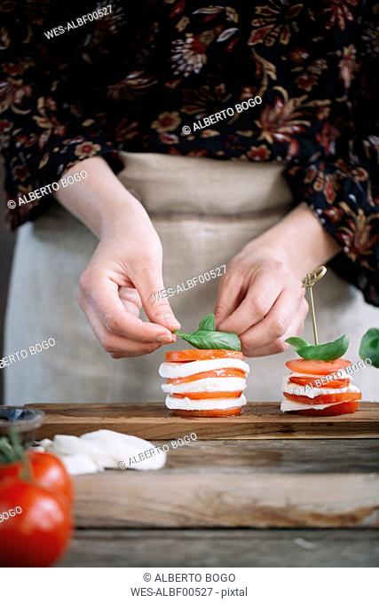 Woman's hands preparing Caprese Salad