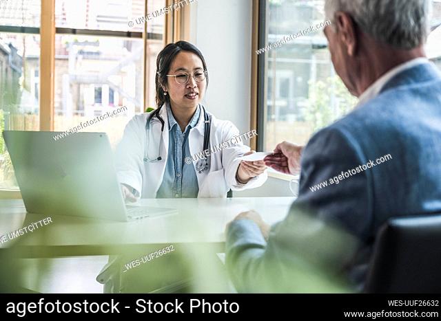 Smiling doctor discussing with patient in medical clinic