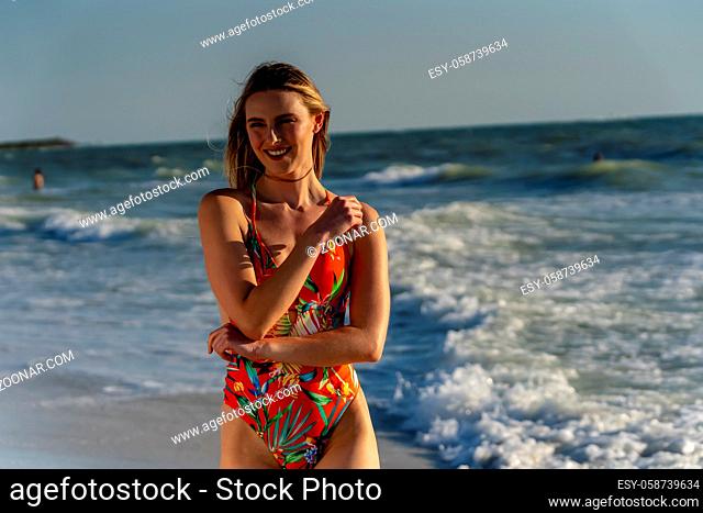 A beautiful brunette bikini model enjoys the weather outdoors on the beach