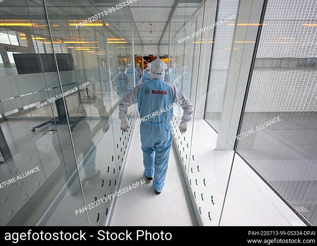 12 July 2022, Saxony, Dresden: Associates and participants in the press tour for ""Bosch Tech Day"" walk in protective suits through an airlock into the clean...