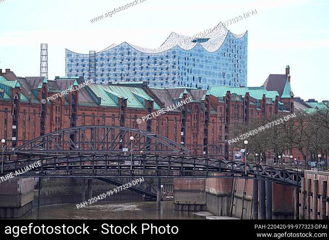 20 April 2022, Hamburg: View of the Elbe Philharmonic Hall in Hafencity. The warehouses of the historic Speicherstadt can be seen in the foreground