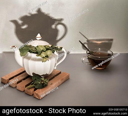 On the table in a teapot and a Cup of healthy herbal tea with sage