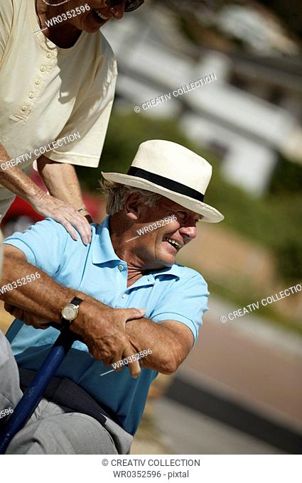 elderly man wearing a sunhat smiling delightfully