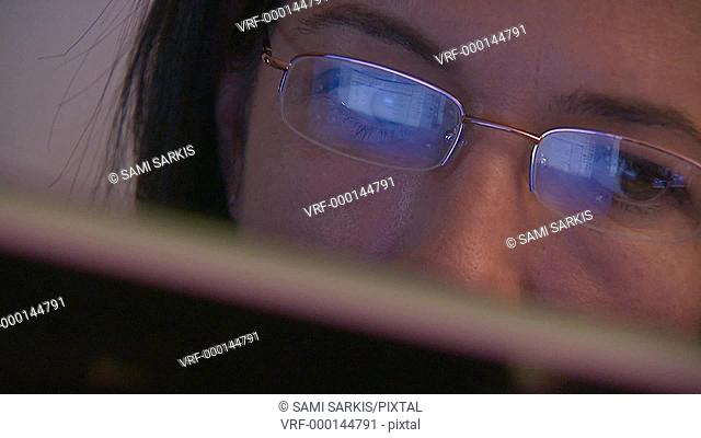 Woman surfing internet, reflection in spectacles, close-up