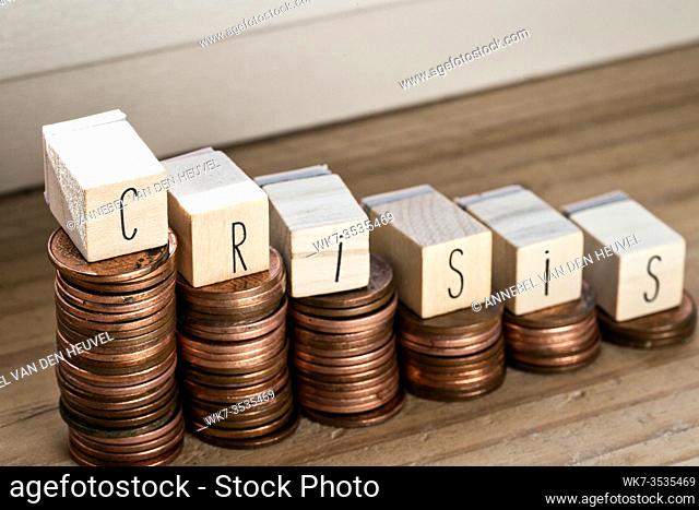 Wooden cubes with the word Crisis and pile of coins, money climbing stairs, business concept background