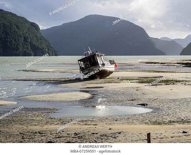 Boat on the sandy beach at the bay of Caleta Tortel, at low tide, Caleta Tortel, Aysen region, Patagonia, Chile