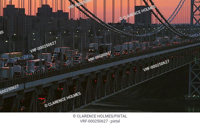 Morning rush hour traffic on the George Washington Bridge crosses the Hudson River between New Jersey and New York just before sunrise