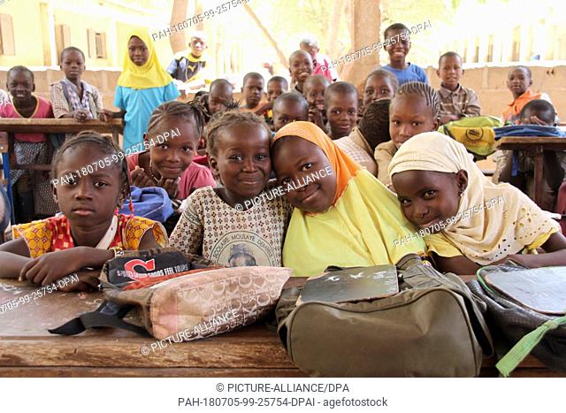 21 March 2018, Mali, Mopti: Seven year old Adiata Zongo (R) and her fellow classmates sit inside a class room of the Moulaye Dembele School built by UNICEF