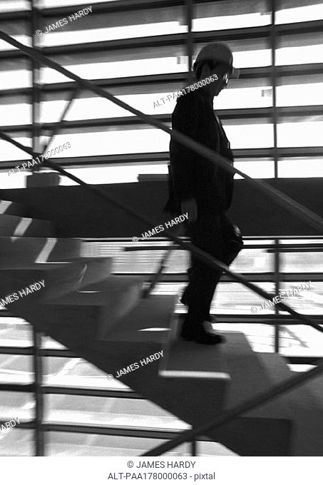 Man on stairs, wearing hard hat, blurred motion, b&w