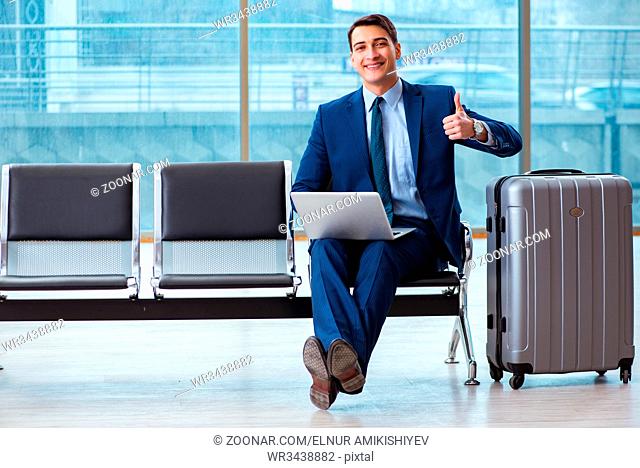 Businessman waiting at the airport for his plane in business class