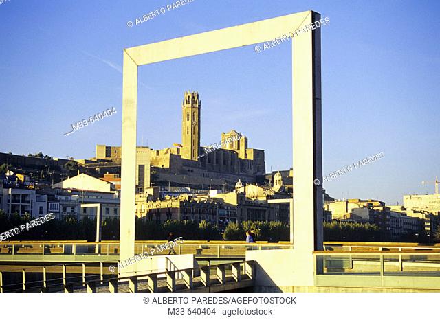 Old cathedral framed by new design metal element in Plaça Blas Infante by Segre river, between Pont Vell and Pont de la Universitat, Lleida