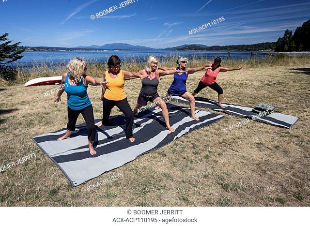Five female friends practice Yoga while camping on Quadra Island, Canada