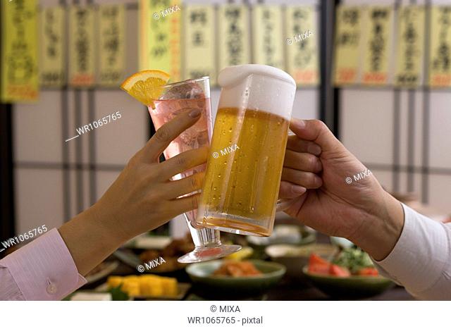 Two People Toasting with Beer and Cocktail at Izakaya