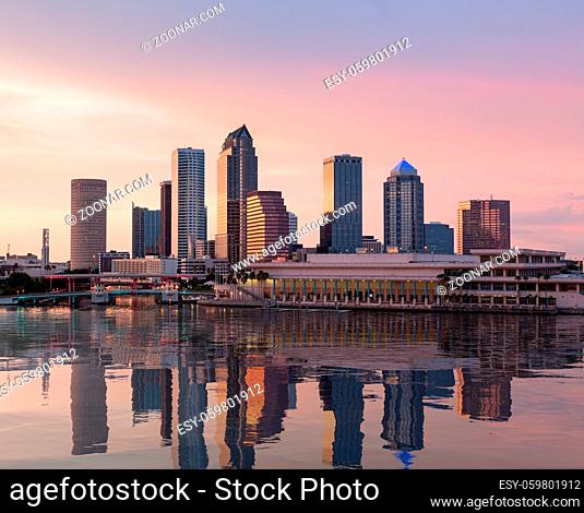 Florida skyline at Tampa with the Convention Center on the riverbank. Sun is just setting at dusk giving a fiery glow to the night sky