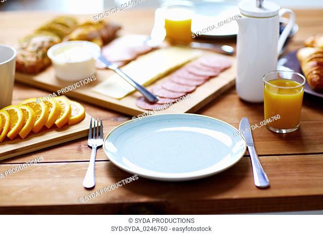 plate and glass of orange juice on table with food