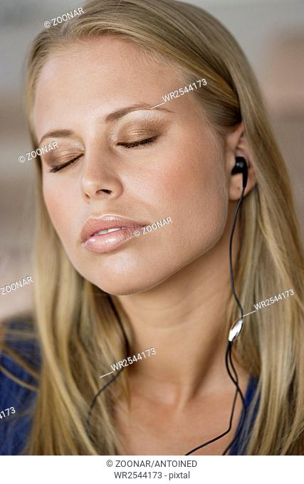 Young woman with MP3 player and closed eyes