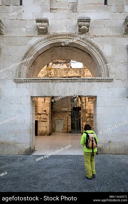 A woman walks through the Golden Gate, entrance to the old town of Split, Split-Dalmatia County, Dalmatia, Croatia, Europe