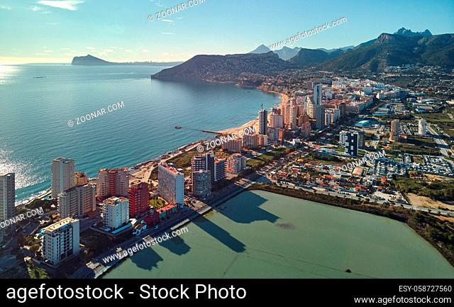 Aerial view Calpe spit between Mediterranean Sea and salt lake. Cityscape, modern skycrapers sunny day green turquoise water