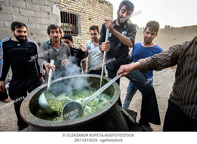 Men serves ritual lunch soup with beans, threads and vegetables for participants of rehearsal of Tazieh, ritual theater of the day of Ashura