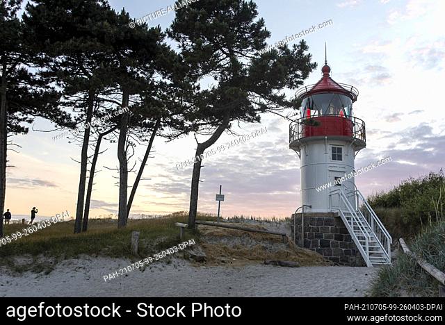 26 June 2021, Mecklenburg-Western Pomerania, Hiddensee: The sun sets behind the Gellen lighthouse. The tower stands in the core zone of the Vorpommersche...