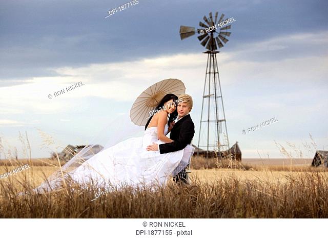 three hills, alberta, canada, a bride and groom in an embrace in a farm field