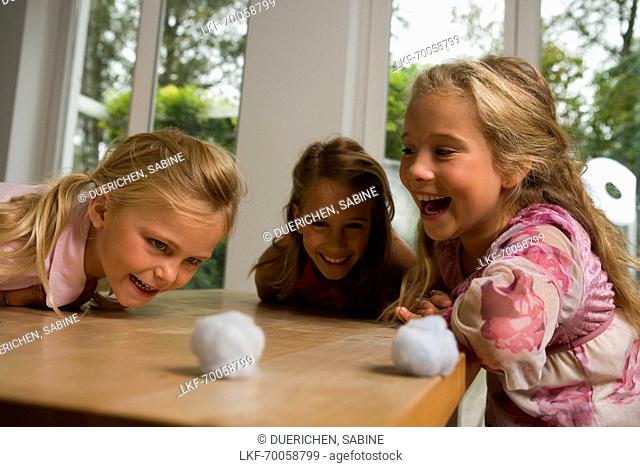 Three girls playing Blowing Cotton Wool, children's birthday party