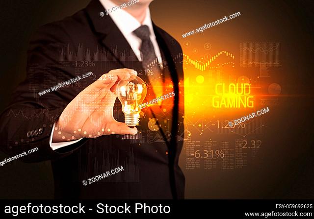 Businessman holding lightbulb with CLOUD GAMING inscription, Business technology concept
