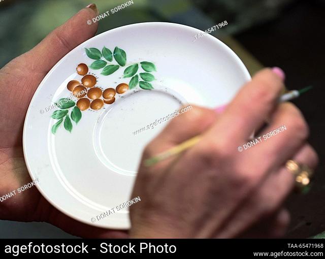 RUSSIA, SVERDLOVSK REGION - DECEMBER 4, 2023: An employee paints a plate at the Sysert porcelain factory. Donat Sorokin/TASS