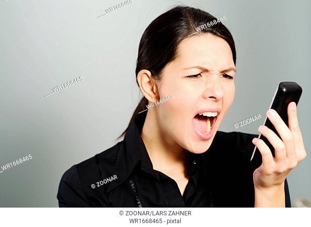 Woman screaming while looking at her mobile phone
