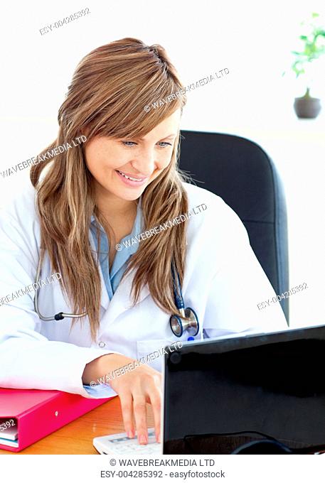 Smiling female doctor working with a laptop