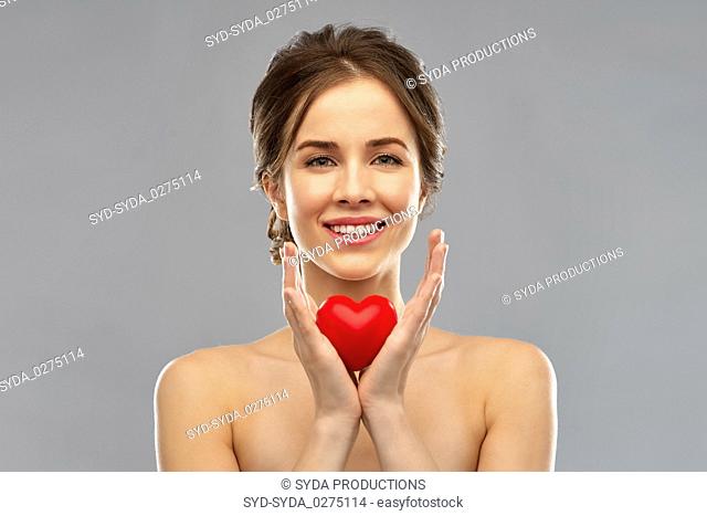 beautiful smiling woman holding red heart