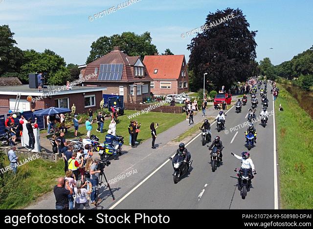 dpatop - 24 July 2021, Lower Saxony, Rhauderfehn: Motorcyclists ride past the house of Kilian, a cancer patient. Thousands of bikers have followed the calls to...